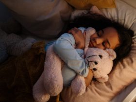 petite fille avec son doudou en peluche