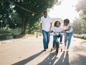 bons parents qui apprennent à leur fille à faire du vélo