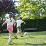 Enfants jouant au ballon sur la pelouse