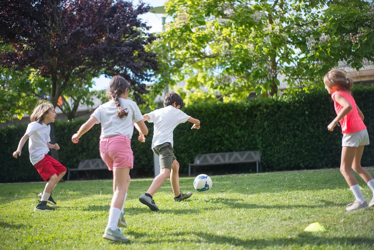 Enfants jouant au ballon sur la pelouse