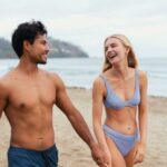 Couple en maillot de bain arborant leur summer body sur la plage