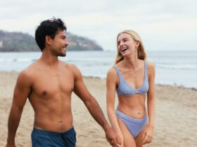 Couple en maillot de bain arborant leur summer body sur la plage