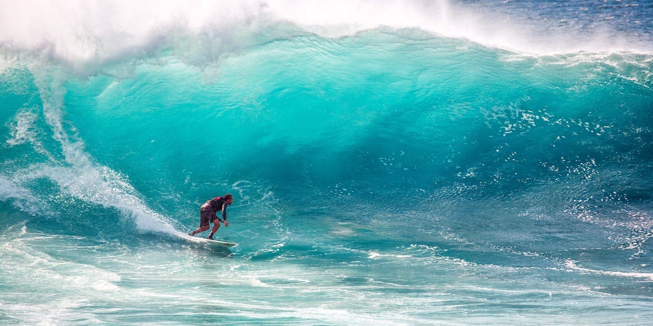 personne qui surfe sur une grosse vague